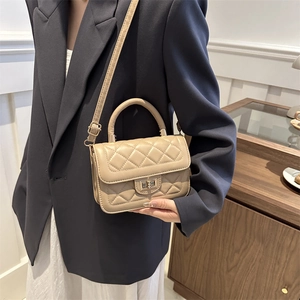 Sac bandoulière beige matelassé avec fermoir rotatif doré et poignée supérieure