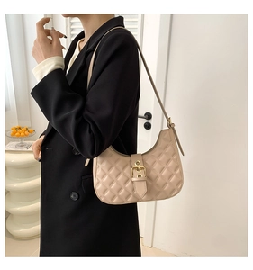 Close-up of beige quilted rhombus shoulder bag featuring a golden buckle and leather strap