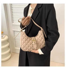Detailed view of beige quilted hobo bag with gold hardware and adjustable strap
