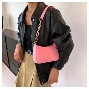 Chic pink crocodile pattern crossbody bag with chain strap shown on a model