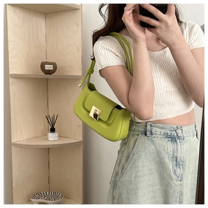 Mirror selfie showing stylish avocado green leather baguette bag with gold buckle
