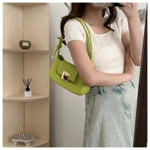 Mirror selfie showing sage green faux leather shoulder bag with gold buckle and knot strap