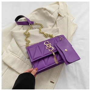 Detail of dark purple quilted texture with gold logo and matching mini earphone pouch