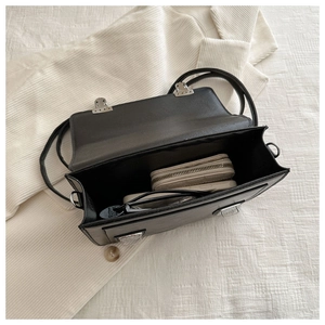 Vue de dessus de l'intérieur spacieux d'un sac en cuir noir avec boucle argentée