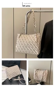 Detail view of the cream tote bag featuring quilted patterns and a silver chain strap
