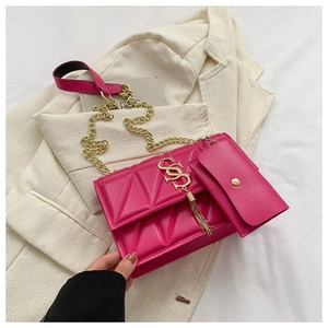 Detail of hot pink quilted shoulder bag with gold metal hardware and small pouch
