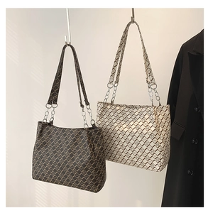 Detail of coffee and cream tote bags with diamond pattern and silver chain straps