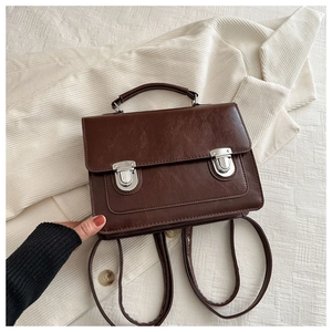 Vue détaillée du sac à dos vintage en cuir marron avec boucles argentées sur tissu