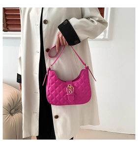 Close-up of quilted magenta hobo bag with a decorative gold buckle on ivory trench coat