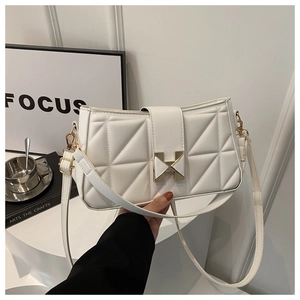 Detail view of white quilted leather bag with golden H-clasp and adjustable strap