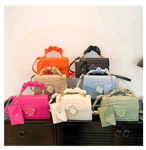 Detail view of colorful stone pattern small square bags with golden buckles and charms