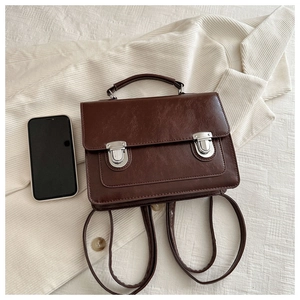 Détail d'un sac rétro en cuir PU marron foncé avec boutons-pression argentés