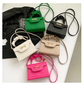 Detailed flat lay of small crossbody bags in five colors with bow hardware and ruched handles
