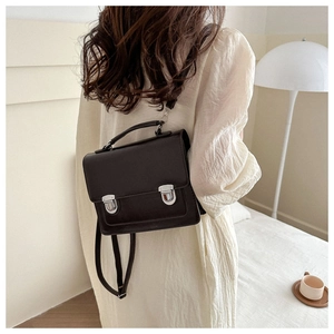 Detailed back view of a vintage black matte backpack with adjustable straps on a model