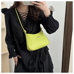 Selfie allo specchio con una borsa a mezzaluna verde fluo su un abito nero