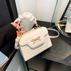 White ruched handle handbag with grid texture and gold bow detail for women