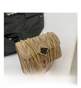 Détail d'un sac matelassé beige avec fermoir carré en métal doré élégant