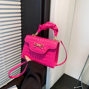 Hot pink crocodile pattern crossbody square bag with gold bow detail and pleated handle