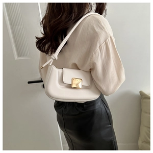 Detailed view of cream minimalist underarm bag with polished square gold buckle and knot detail