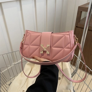 Pink quilted faux leather shoulder bag with gold H-buckle in a shopping cart setting