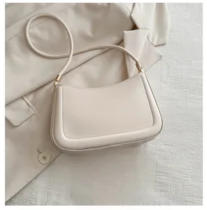 Detail view of the cream shoulder bag showing leather texture and interior space for a phone