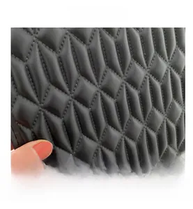 Macro shot of black quilted lattice texture on a faux leather crossbody square bag