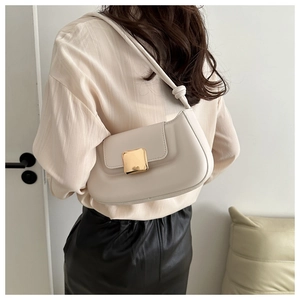 Detail of off-white leather shoulder bag with gold square buckle and knot strap detail