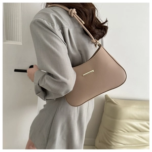 Détail d'un sac à bandoulière en cuir beige avec boucle dorée et bandoulière nouée