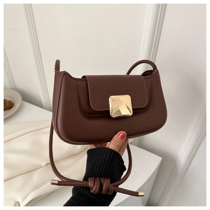 Detail of vintage brown leather handbag with large gold square buckle and shoulder strap