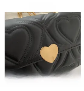Close-up of black quilted heart leather texture with elegant gold heart-shaped buckle