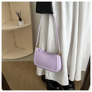 Detail of lavender PU leather shoulder bag with sleek lines and golden metal hardware