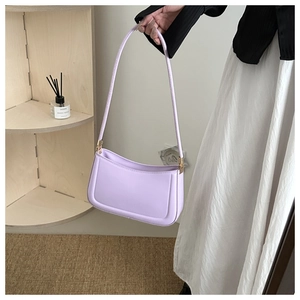 Close-up of a lavender shoulder bag with smooth faux leather and elegant gold hardware