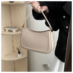 Close-up of beige faux leather baguette bag with minimalist U-shaped stitching