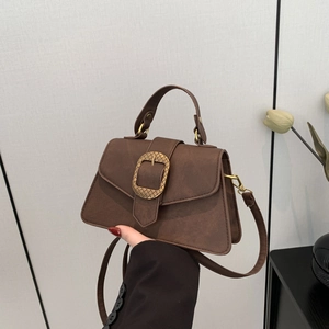 Vintage brown leather underarm bag with decorative metal buckle and adjustable strap