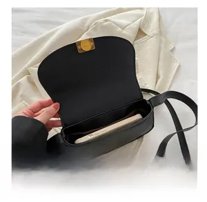 Interior view of black matte crossbody saddle bag showing capacity for a smartphone