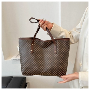 Detailed macro view of vintage brown monogram pattern and golden rivets on tote bag