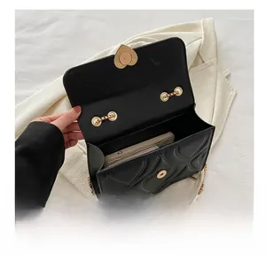 Interior capacity view of black quilted heart crossbody bag with golden chain strap
