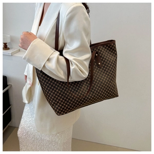 Detailed close-up of a large tote bag featuring geometric dot patterns and leather handles