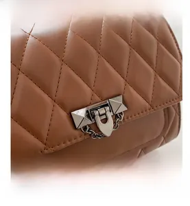 Detail of brown quilted shoulder bag with silver pyramid studs and metallic clasp