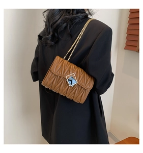 Détail du sac matelassé caramel avec chaîne dorée et fermoir en métal vintage