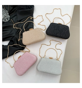 Dettaglio di pochette da sera glitterate in oro, argento, rosa e nero con catena