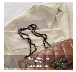 Close-up of brown quilted crossbody bag with black chain strap and metal lock detail