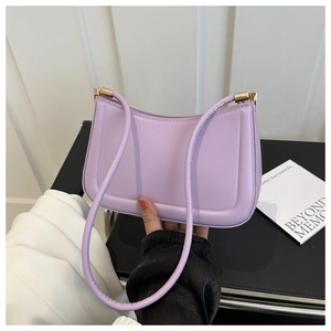 Detail of purple matte leather baguette bag with minimalist geometric embossing and gold hardware