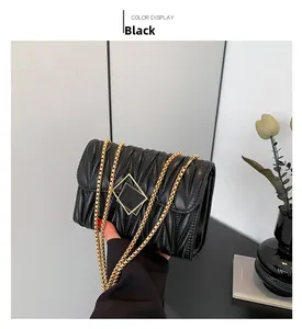 Détail du sac bandoulière noir matelassé avec chaîne dorée épaisse et boucle en métal brillant