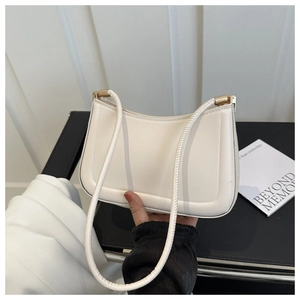 Detail of white PU leather shoulder bag with gold hardware and minimalist stitching