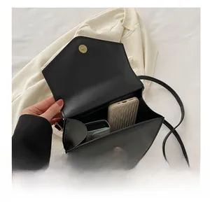 Interior view of black faux leather crossbody bag showing storage capacity for phone and wallet