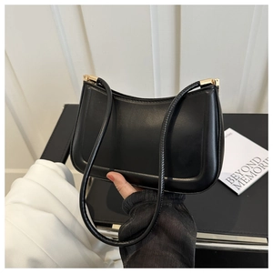 Detail of vintage black baguette bag with smooth matte leather and golden metal buckle