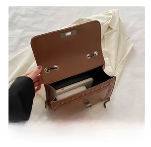 Interior view showing capacity of brown quilted crossbody bag with phone and card holder