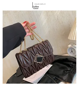 Détail du sac bandoulière marron café matelassé avec chaîne dorée et finition en similicuir