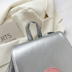 Detalle del asa de cuero sintético plateado con costuras finas de alta calidad del bolso